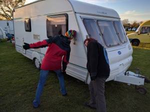 Sharon and Gaynor very carefully moving John and Carol's caravan into position using just their heads